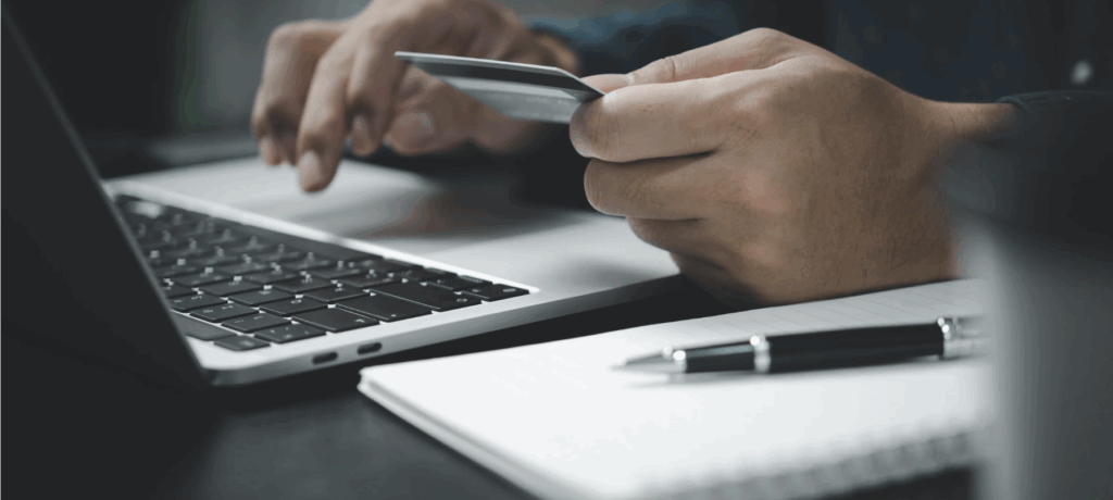 Persona che effettua un pagamento online con carta di credito utilizzando un laptop, simbolo della diffusione dei pagamenti digitali nel settore turistico.